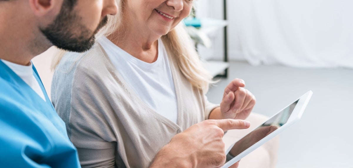 health professional with patient and tablet stock medium res